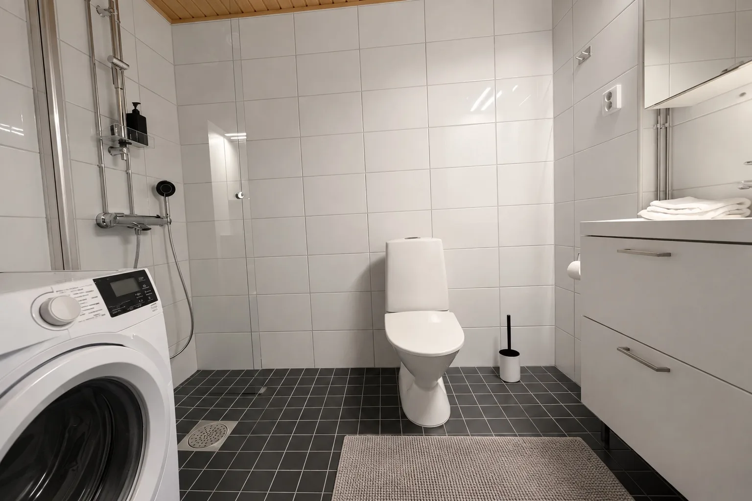 Kylpyhuone, jossa on suihku ja pesukone